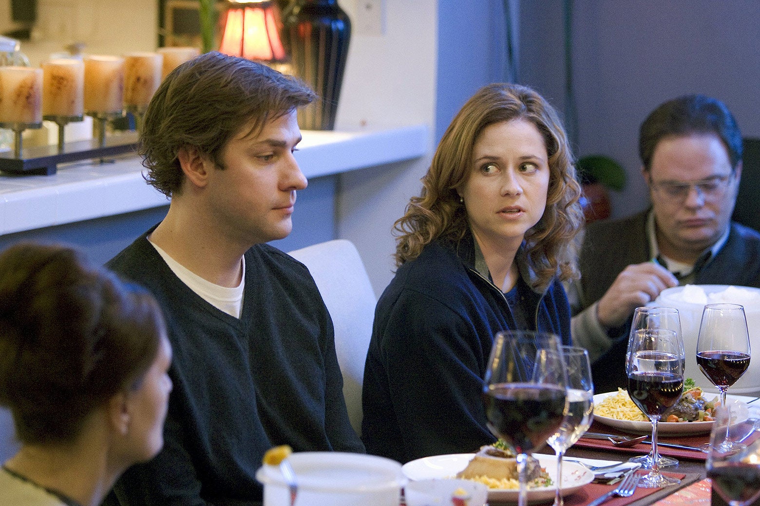 Jim and Pam, seated at a table, look uneasy.
