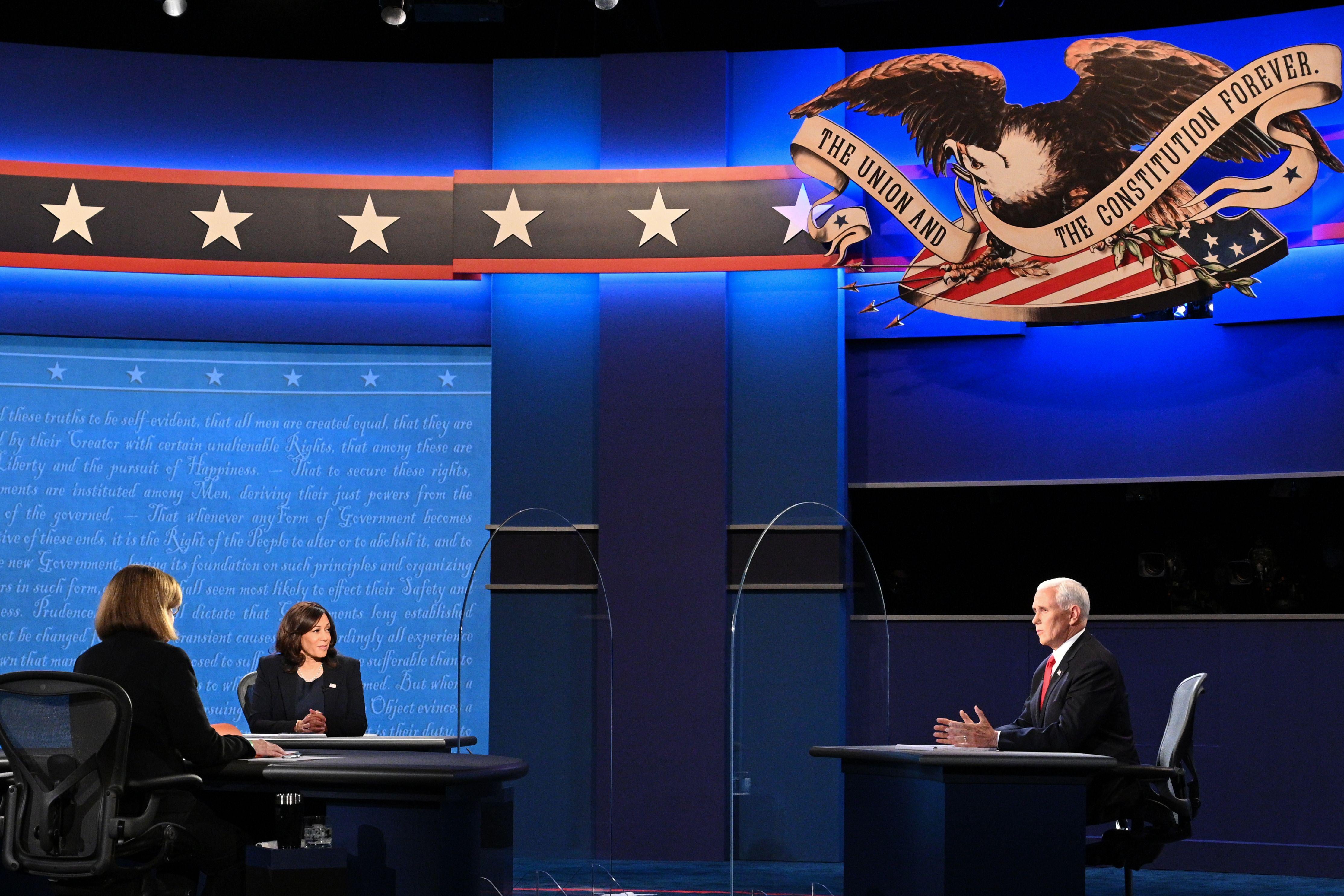 Harris and Pence are seen separated by glass onstage, with Susan Page watching.