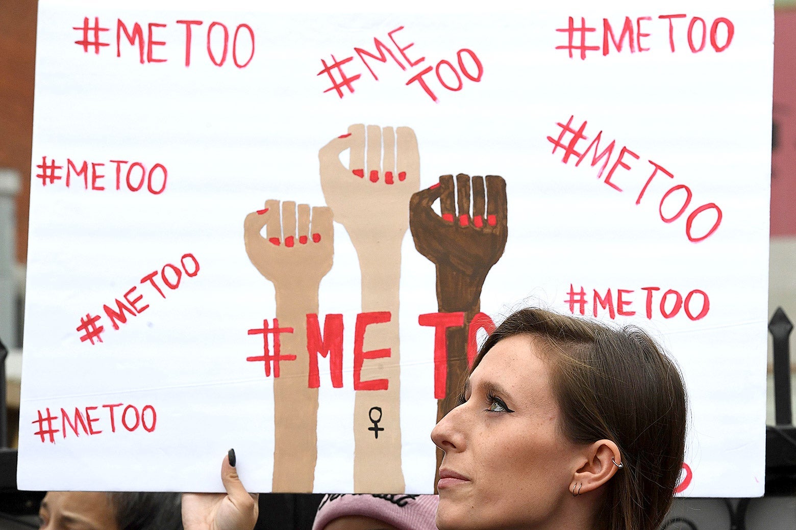 A woman holds a sign during #MeToo march.