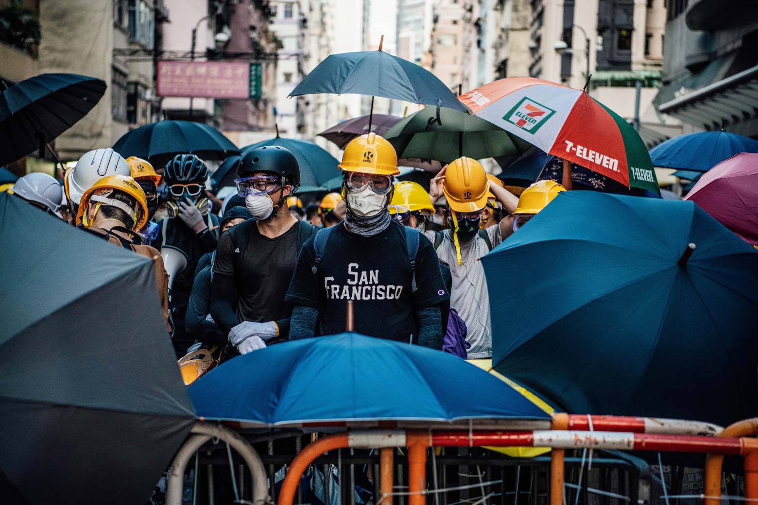 Masked protesters stand behind a makeshift barricade on July 28 in Hong Kong.