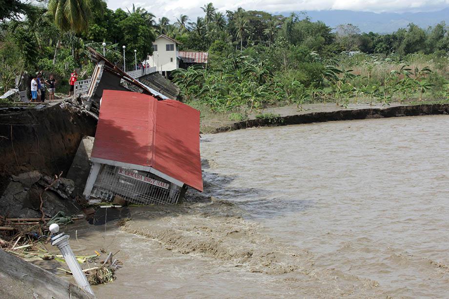 People look at a damaged village hall in the aftermath of Super Typhoon Haiyan in Iloilo on November 9, 2013.