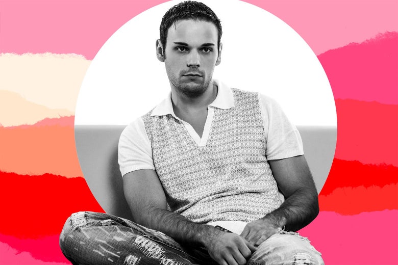 A man slouches and frowns as he sits on a couch.