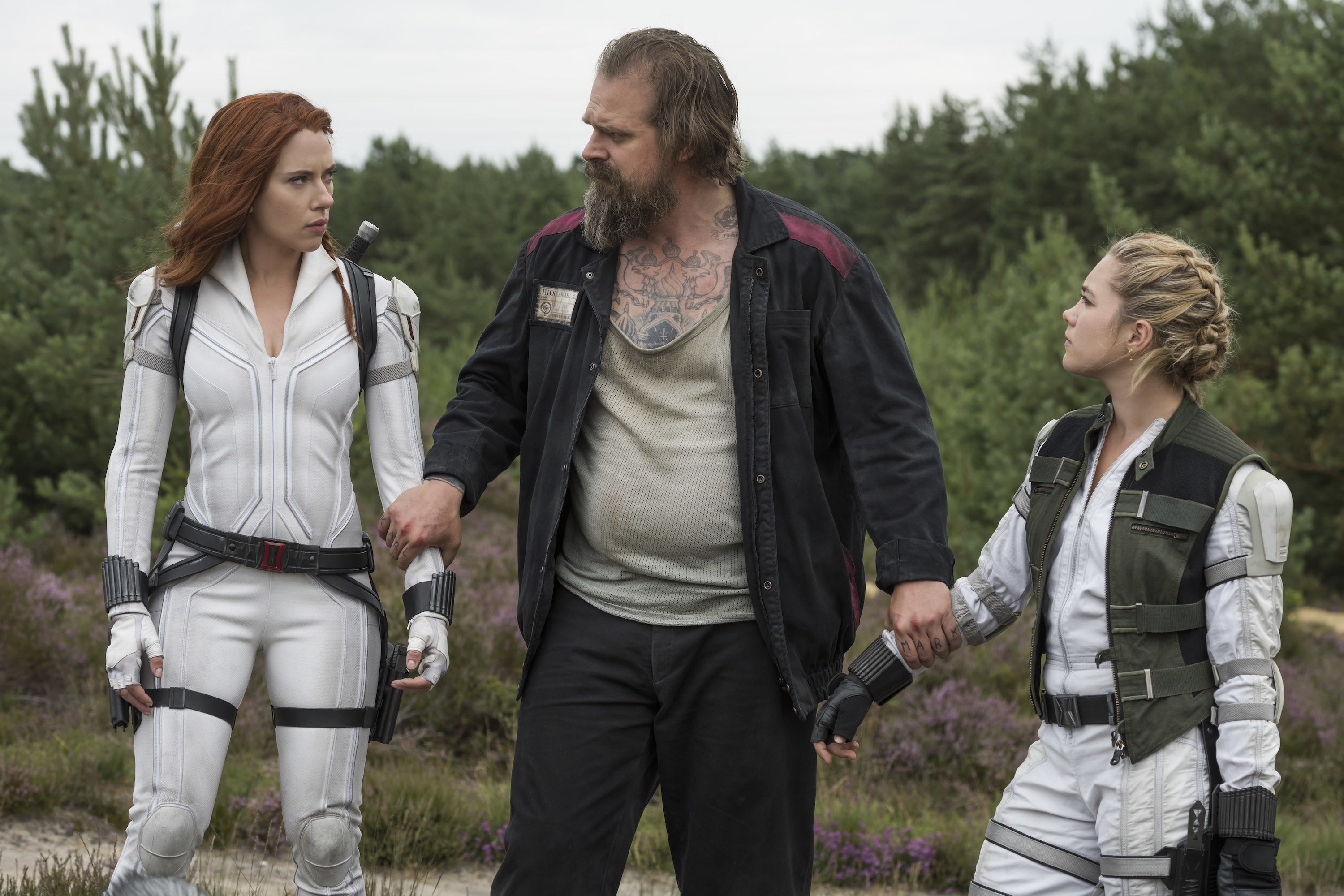Black Widow and her sister, in white jumpsuits, on either side of their father, Alexei.