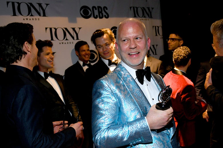Ryan Murphy holds an award while standing amid a crowd.