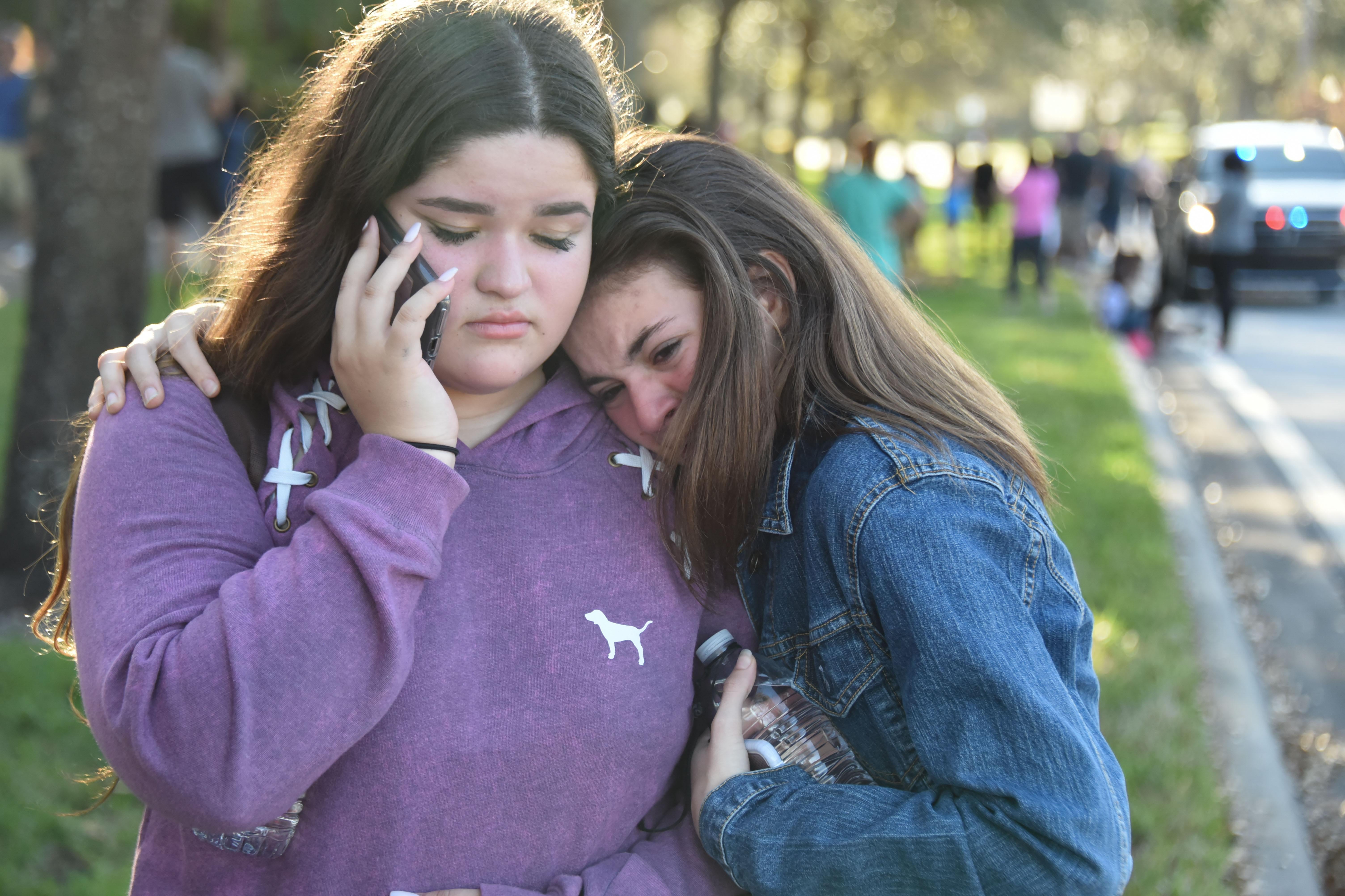 Students react following a shooting at Marjory Stoneman Douglas High School in Parkland, Florida, a city about 50 miles (80 kilometers) north of Miami on February 14, 2018.
A gunman opened fire at the Florida high school, an incident that officials said caused 'numerous fatalities' and left terrified students huddled in their classrooms, texting friends and family for help.
The Broward County Sheriff's Office said a suspect was in custody. / AFP PHOTO / Michele Eve Sandberg        (Photo credit should read MICHELE EVE SANDBERG/AFP/Getty Images)