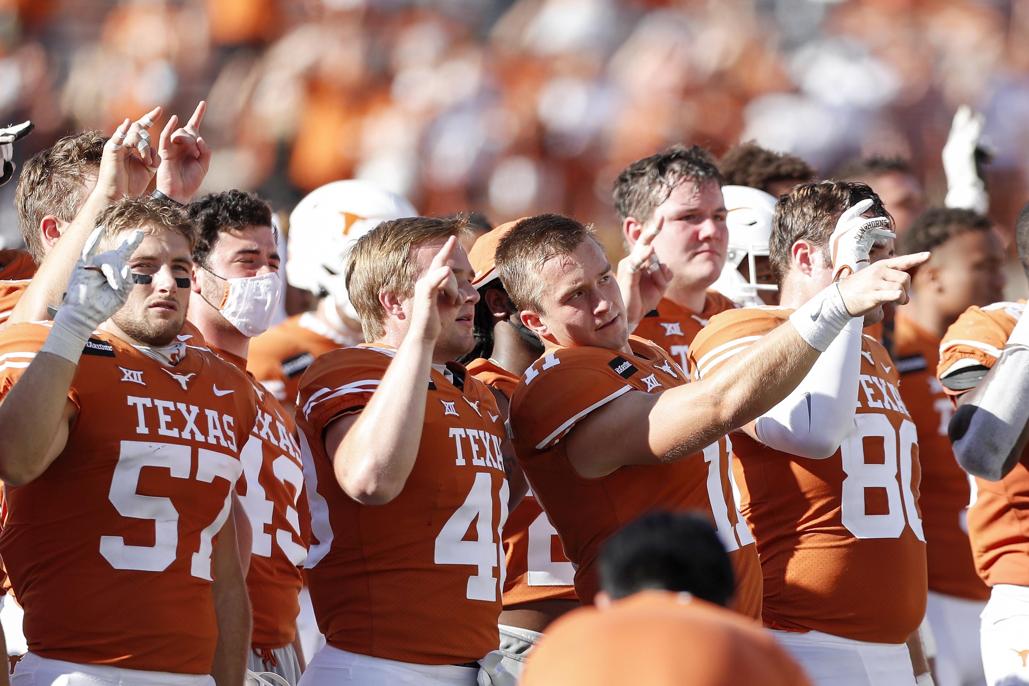 The Texas Longhorns stand for The Eyes of Texas, making the "Hook 'em Horns" gesture with their hands after the game