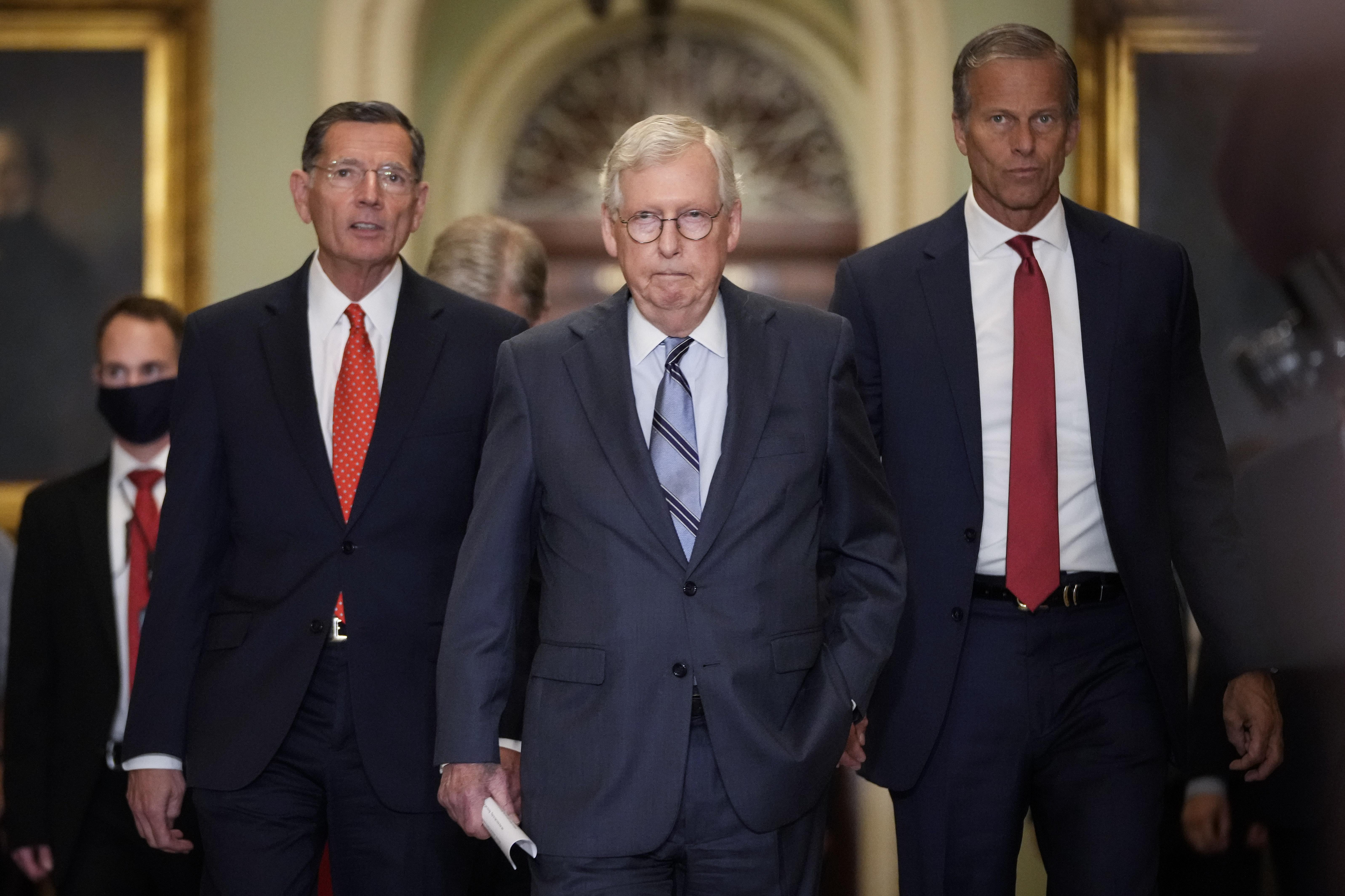 three old white men in suits walking
