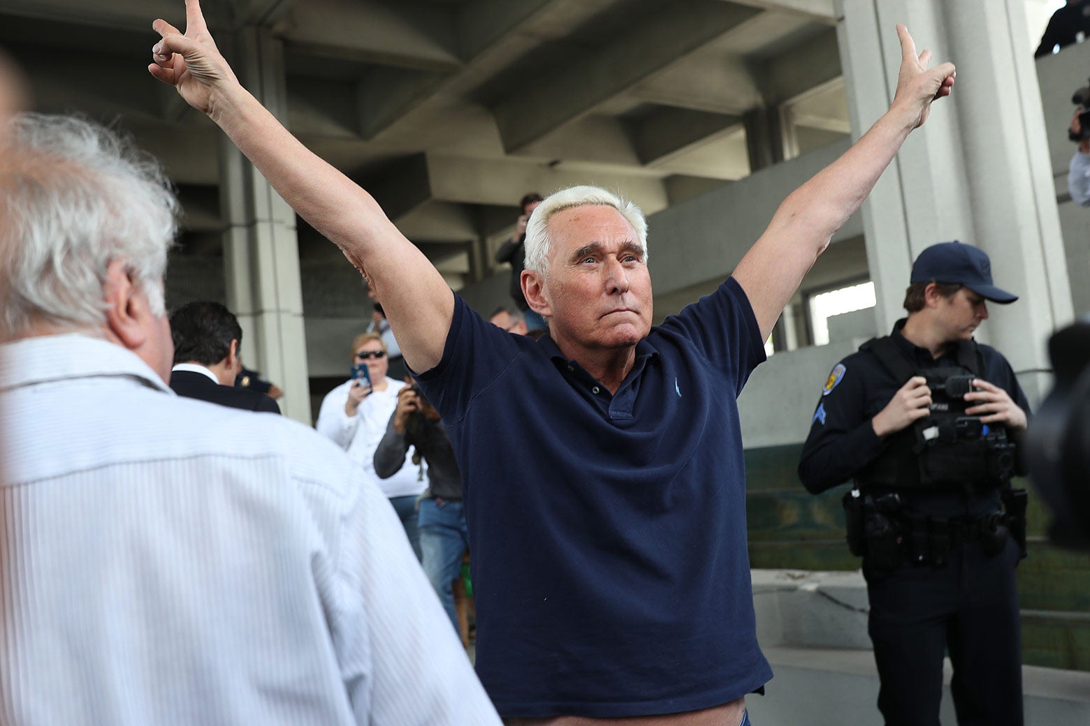 Roger Stone leaves the courthouse with both arms raised in a Nixon salute.