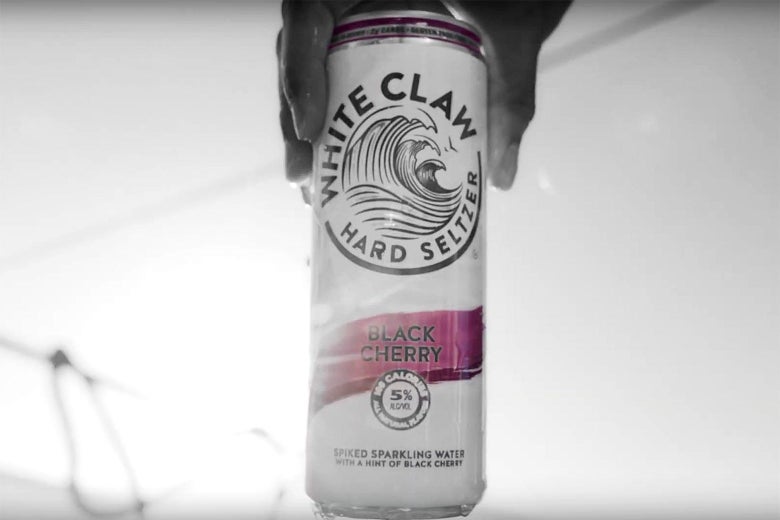 A hand holds a can of White Claw hard seltzer.