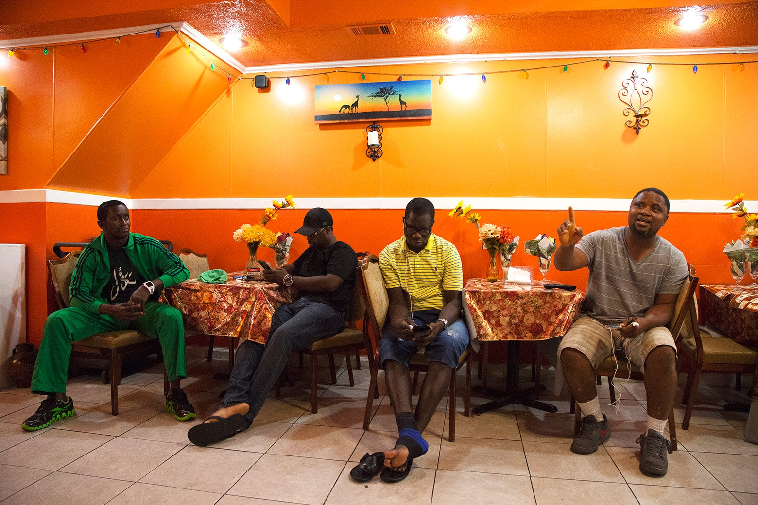 Men discuss the upcoming Sierra Leonean presidential election inside Tasty African restaurant on Woodland Avenue.