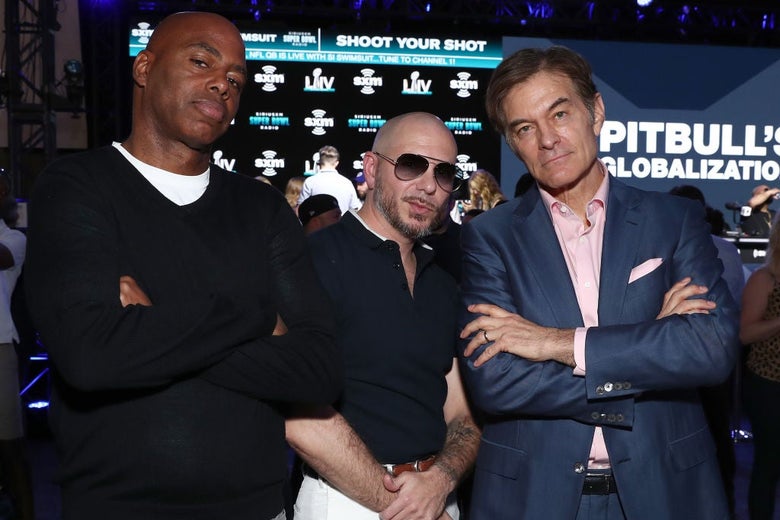 The three men stand with their arms crossed on a studio set in front of what appears to be a photo backdrop and a large digital screen that says "Pitbull's Globalization"