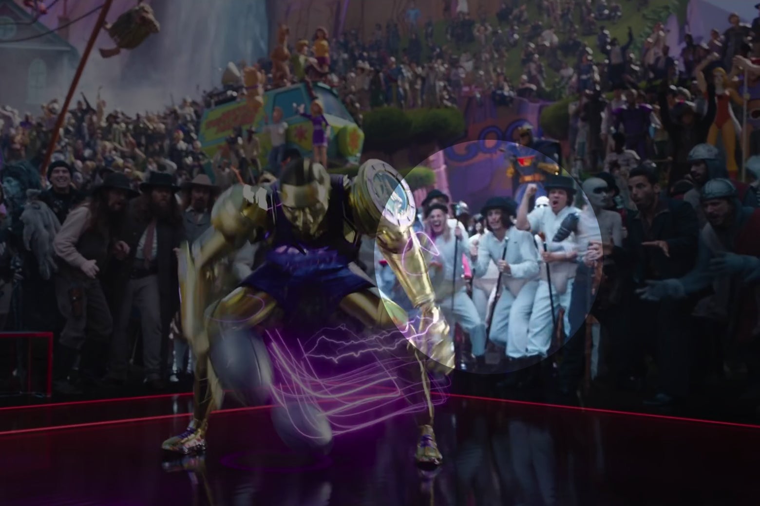 A shot from Space Jam: A New Legacy showing Cronos, a gold robot, dribbling on a basketball court. In the crowd, cheering, are three characters from A Clockwork Orange.