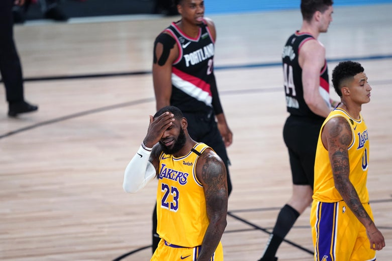 LeBron James puts his hand to his head while walking on a court during a game.