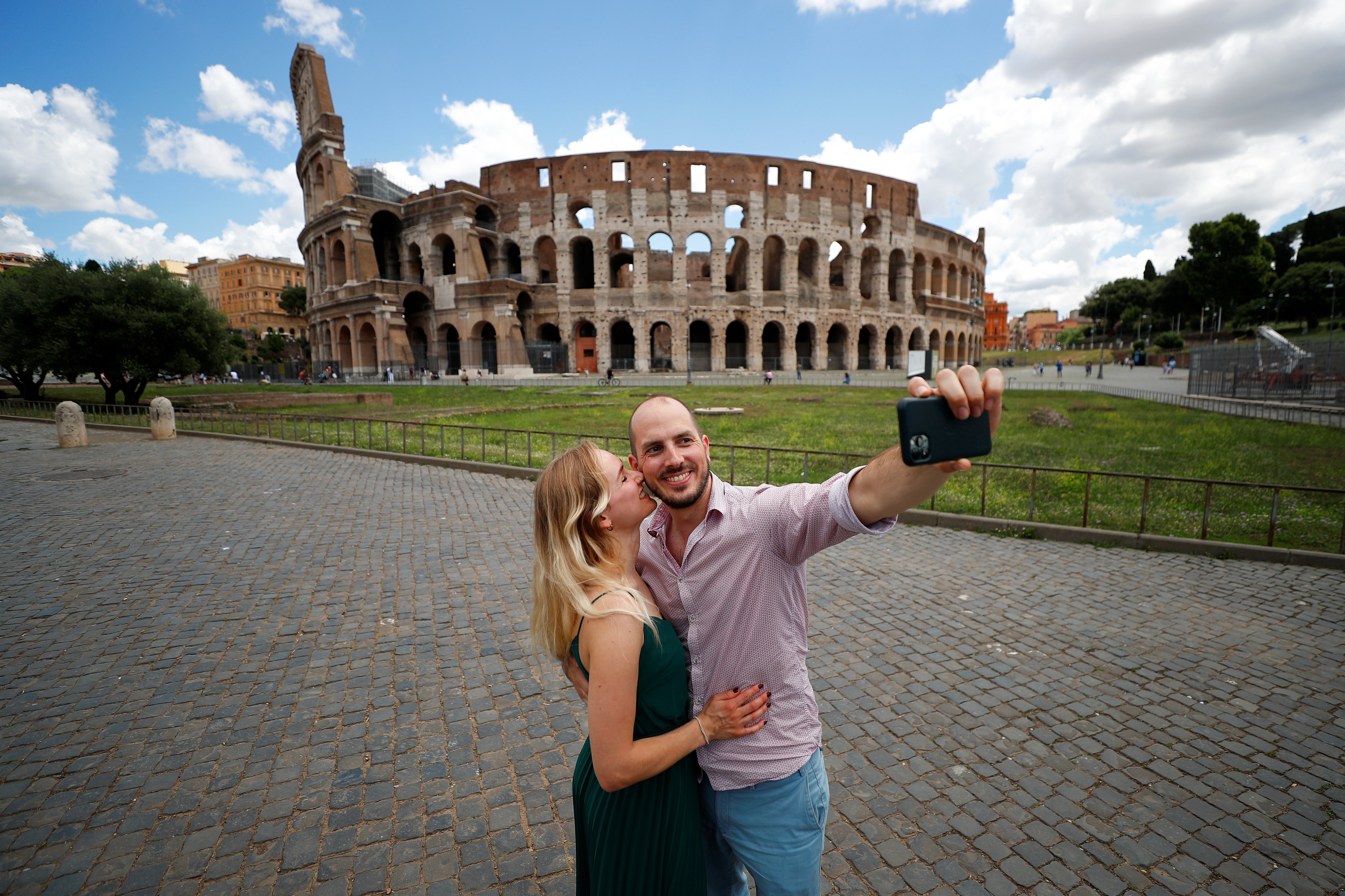 A couple taking a selfie in front of the Colosseum