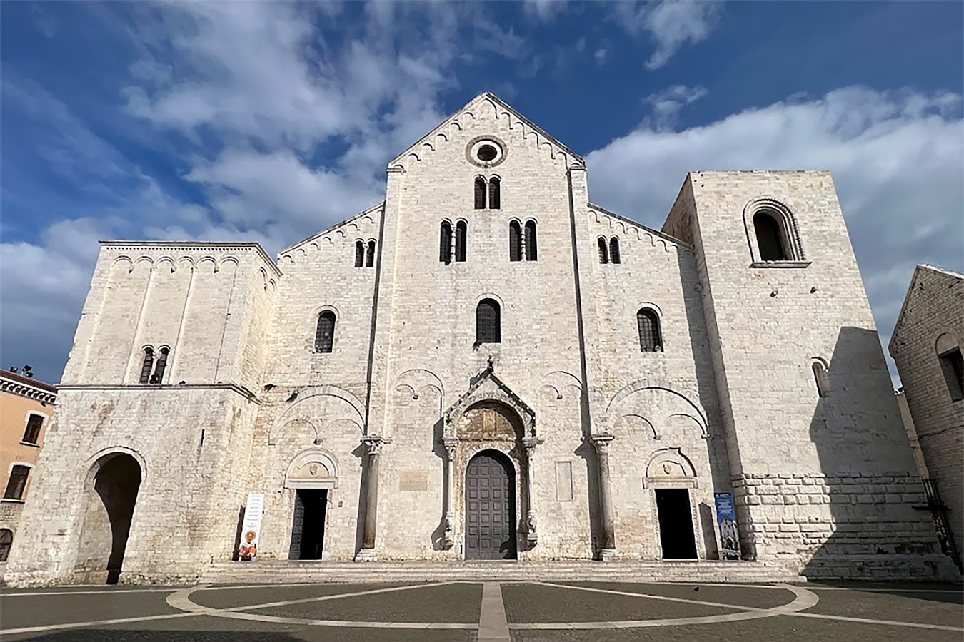 A moderately sized white stone church with rounded arches.