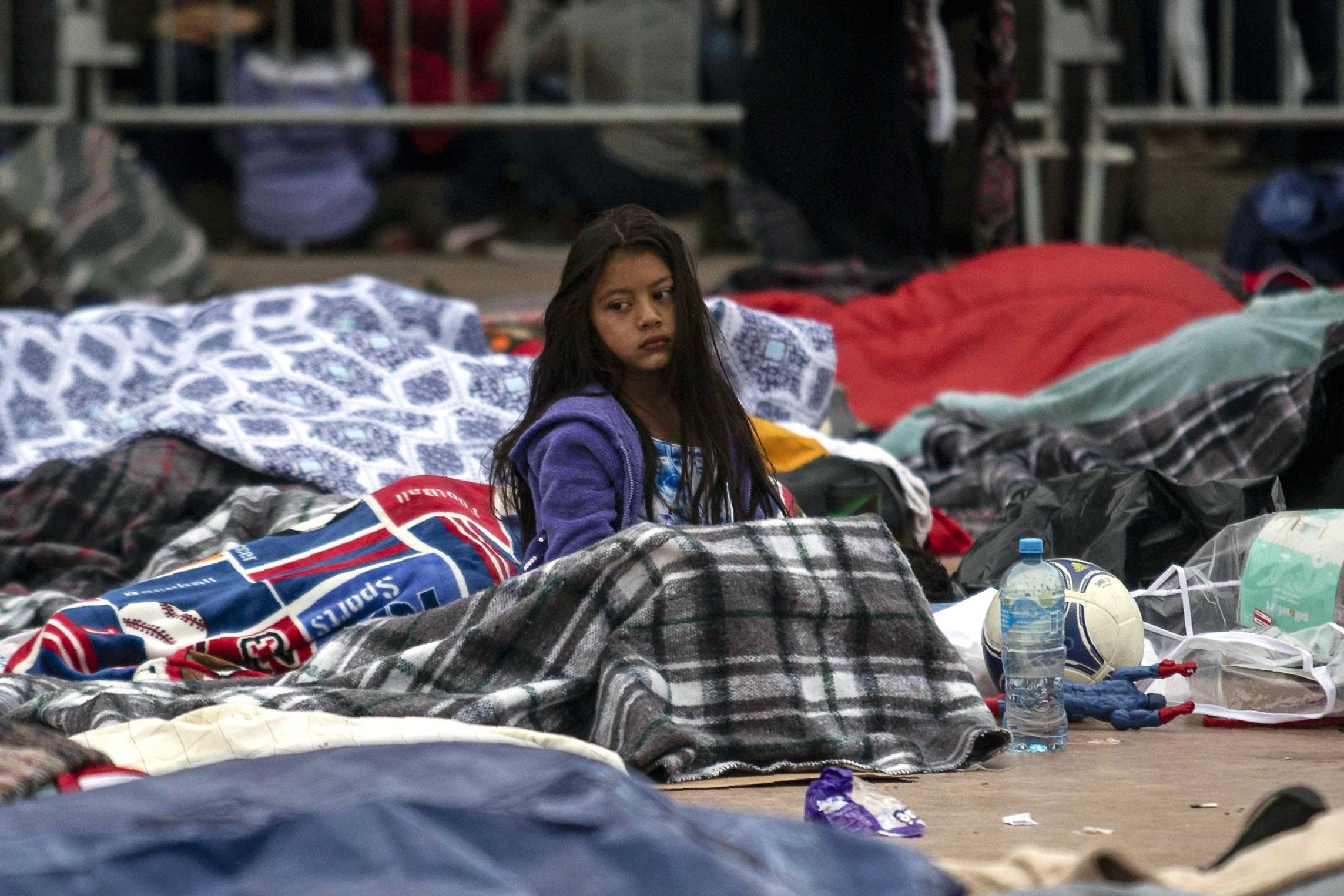 Central American migrants travelling in the 'Migrant Via Crucis' caravan sleep outside 'El Chaparral' port of entry to US while waiting to be received by US authorities, in Tijuana, Baja California State, Mexico on April 30, 2018. - According to the U.S. Customs and Border Protection on Sunday, none of the migrants from the caravan was processed for asylum because the agency had reached capacity for the day for migrants seeking asylum. At least 150 Central American migrants reached the border between Mexico and the United States on Sunday, determined to seek asylum from the US. The group arrived in the Mexican border town of Tijuana, part of a caravan of more than 1,000 people who set out from Mexico's southern border on March 25. (Photo by GUILLERMO ARIAS / AFP)        (Photo credit should read GUILLERMO ARIAS/AFP/Getty Images)
