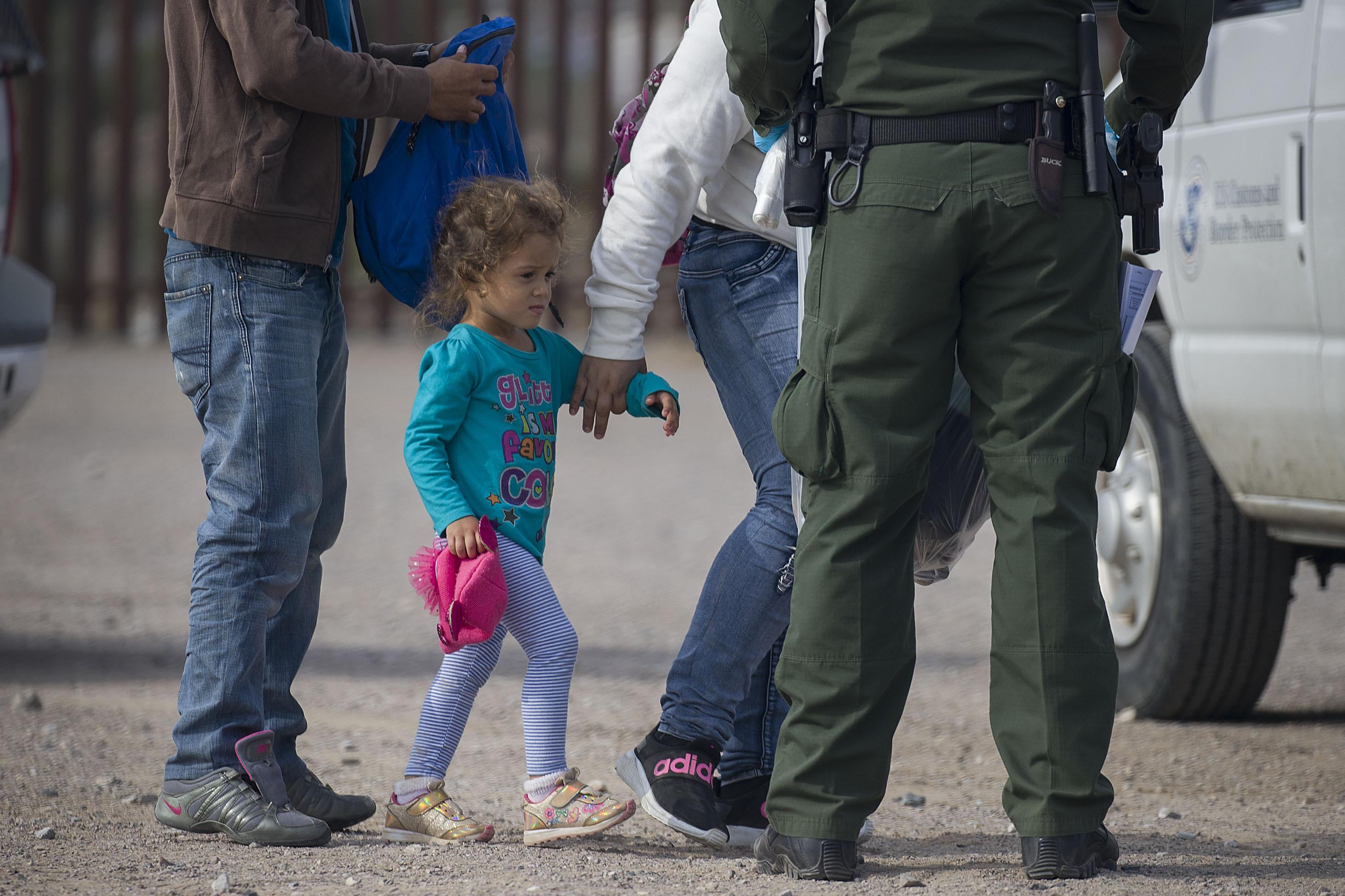 A young child is processed by Border Patrol agents.