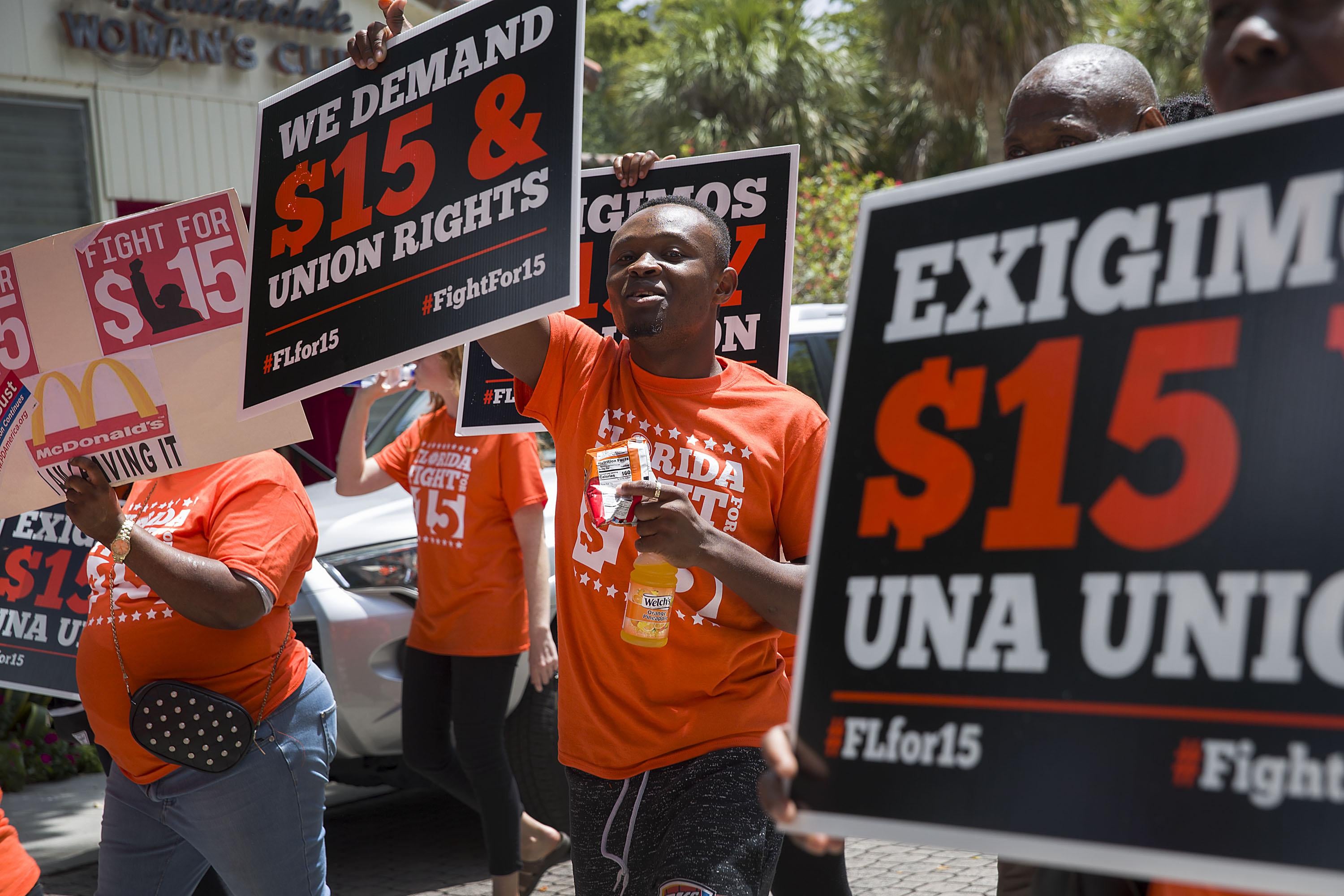 Activists march and carry signs demanding that McDonald’s raise workers’ wages to a $15 minimum on May 23, 2019, in Fort Lauderdale, Florida
