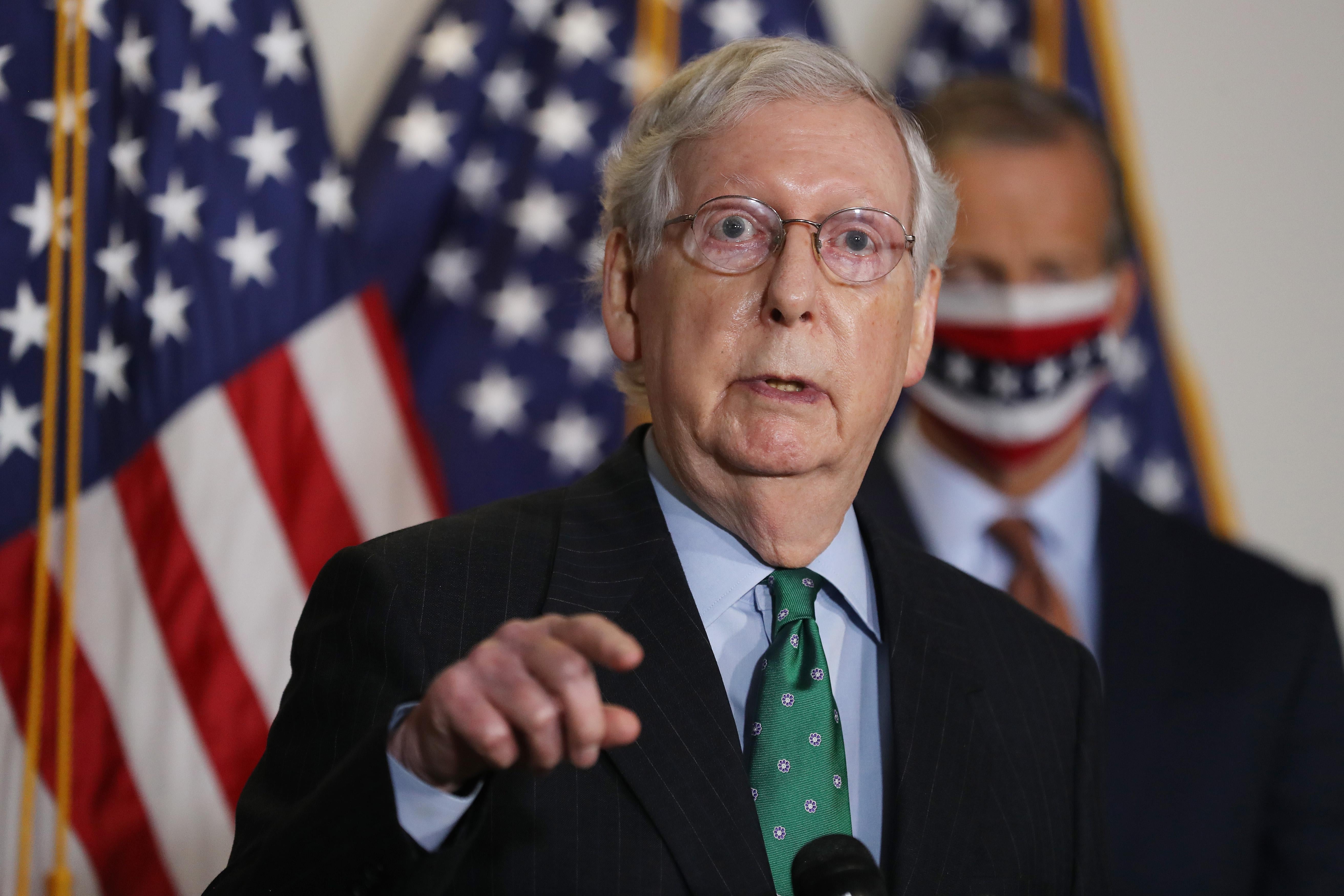 Mitch McConnell points as he speaks at a podium on Capitol Hill on Sept. 30