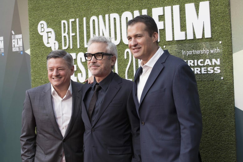 Ted Sarandos, Alfonso Cuarón, and Scott Stuber on a red carpet.