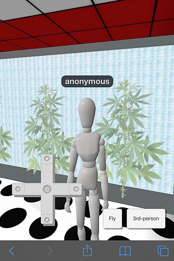 A digital figurine that says, "anonymous" over it stands in front of green plants.