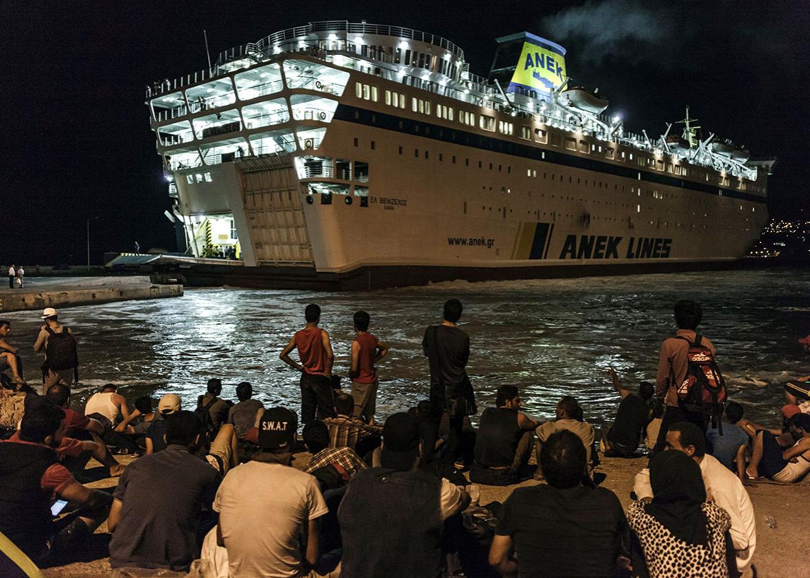Syrian migrants wait on a dock to board on the Eleftherios Veniz