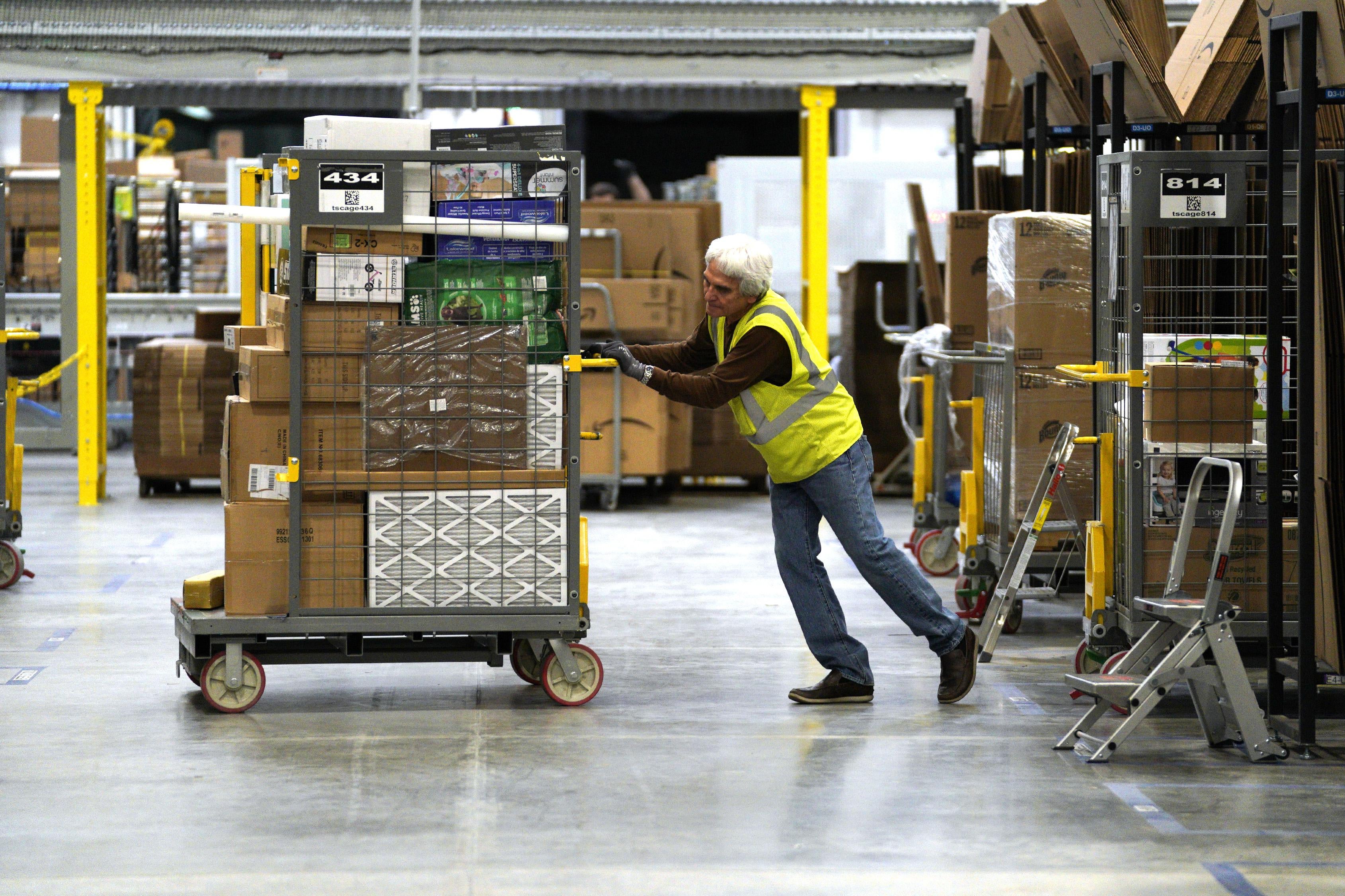 A worker moves boxes at an Amazon fulfillment center.