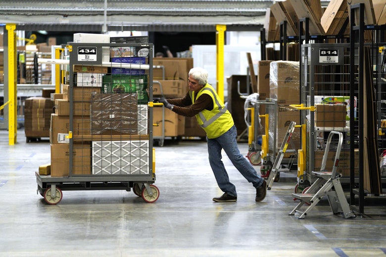 A worker moves boxes at an Amazon fulfillment center.
