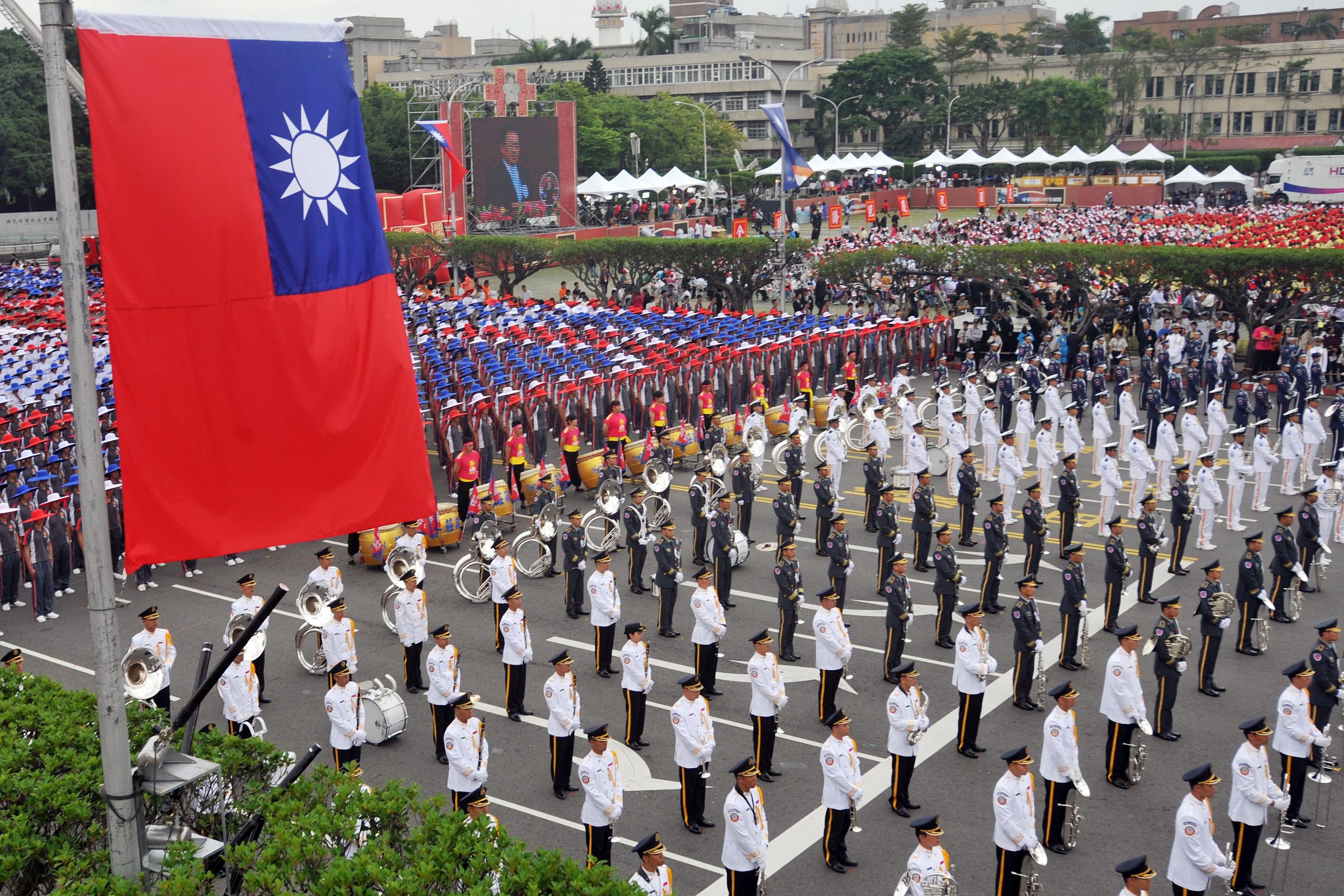 Members of a Taiwanese military band and people wearing hats in the colors of Taiwan’s national flag.