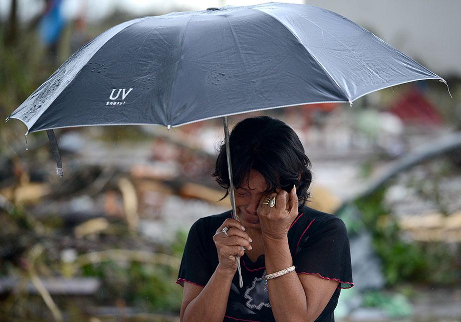 A woman mourns in front of her husband's dead body in a street of Tacloban, eastern island of Leyte on November 10, 2013.