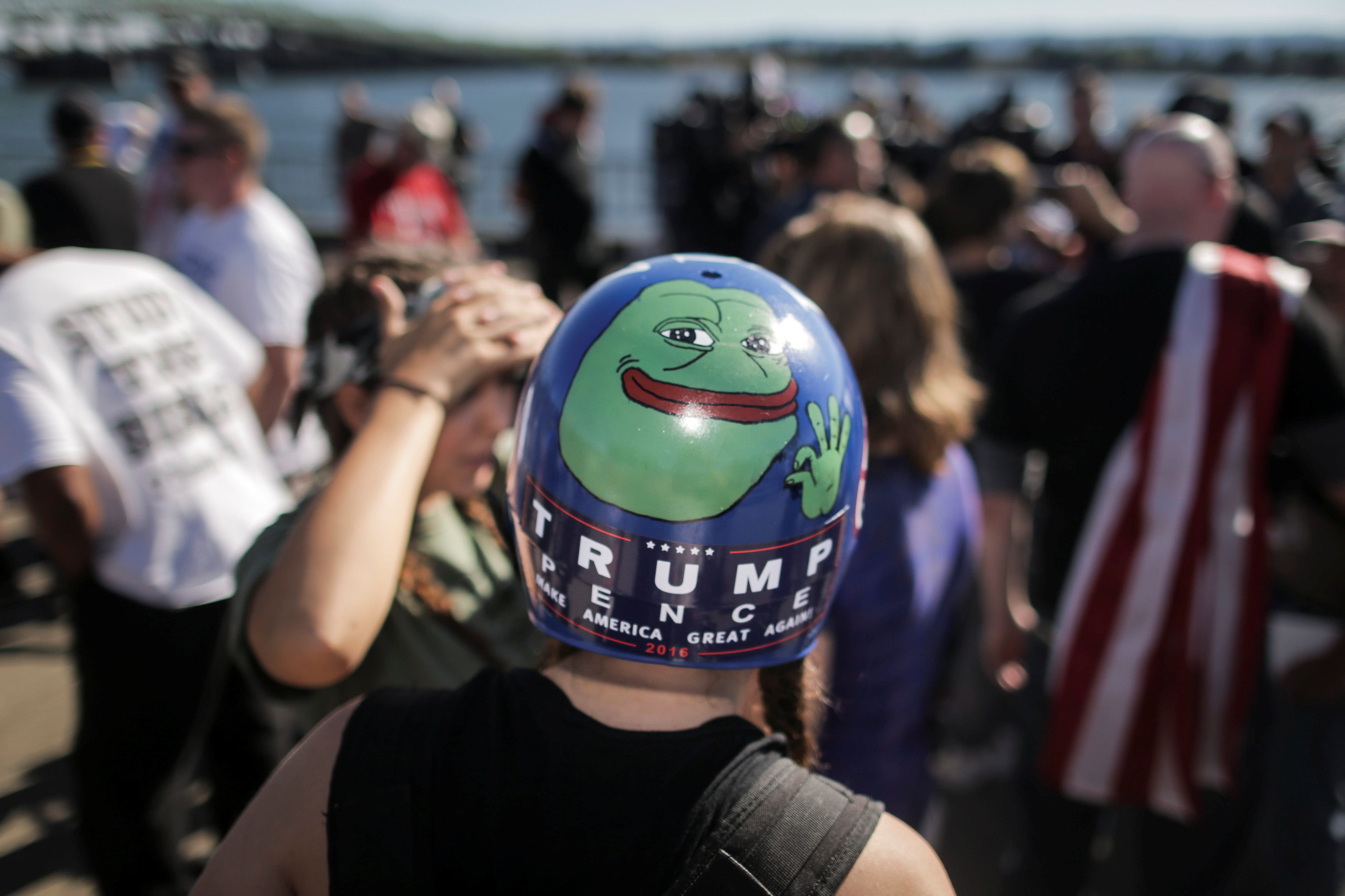 A Trump supporter wears a helmet with a hand-painted Pepe the Frog image.