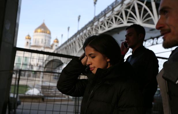 Nadezhda Tolokonnikova walks to her news conference at Dozhd TV channel with the Cathedral of Christ the Savour on the background, Dec. 27, 2014.