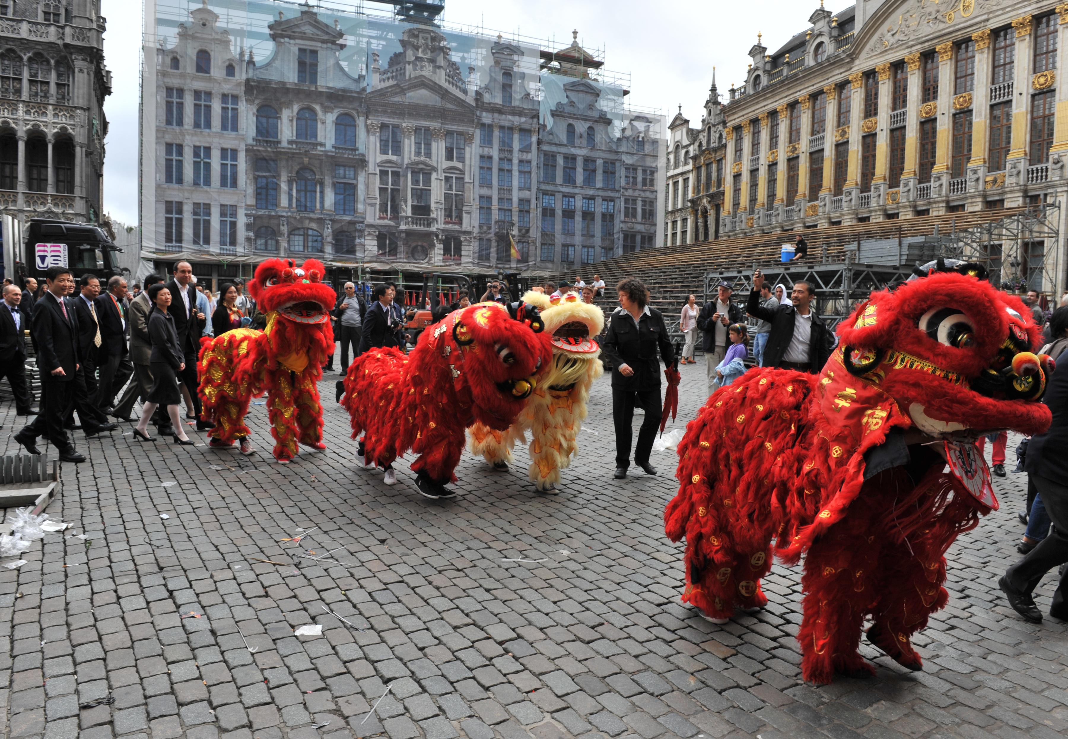 Chinese lions open the way on July 6, 2012, on the Grand Place in Brussels, to Belgian and Chinese personalities, heading to attend a ceremony at the nearby famous Manneken-Pis fountain.