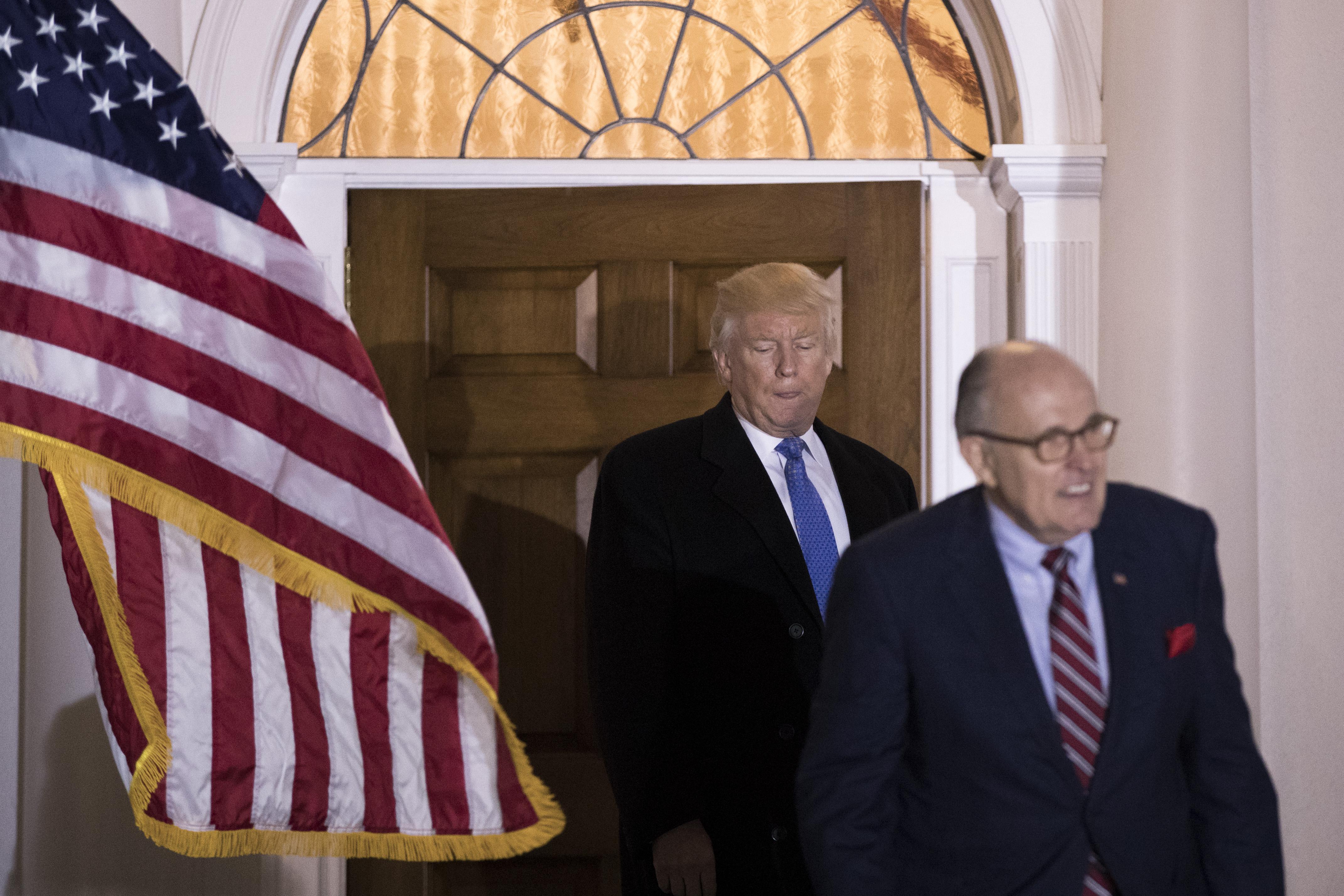 Donald Trump walking behind Rudy Giuliani.