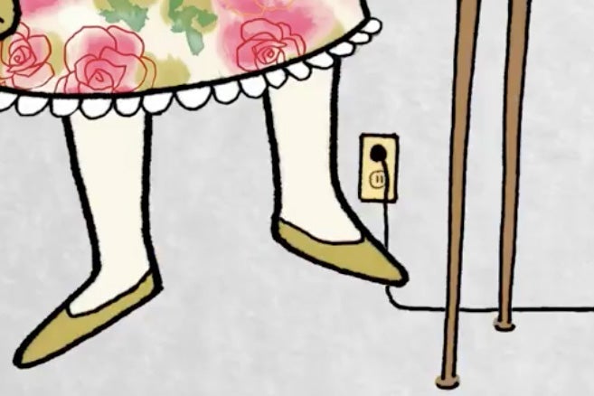 A foot is seen near a socket with a plug in it.