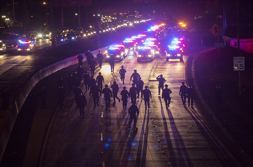 California Highway Patrol officers walk to clear the 101 freeway from protesters in Los Angeles on Nov. 25, 2014