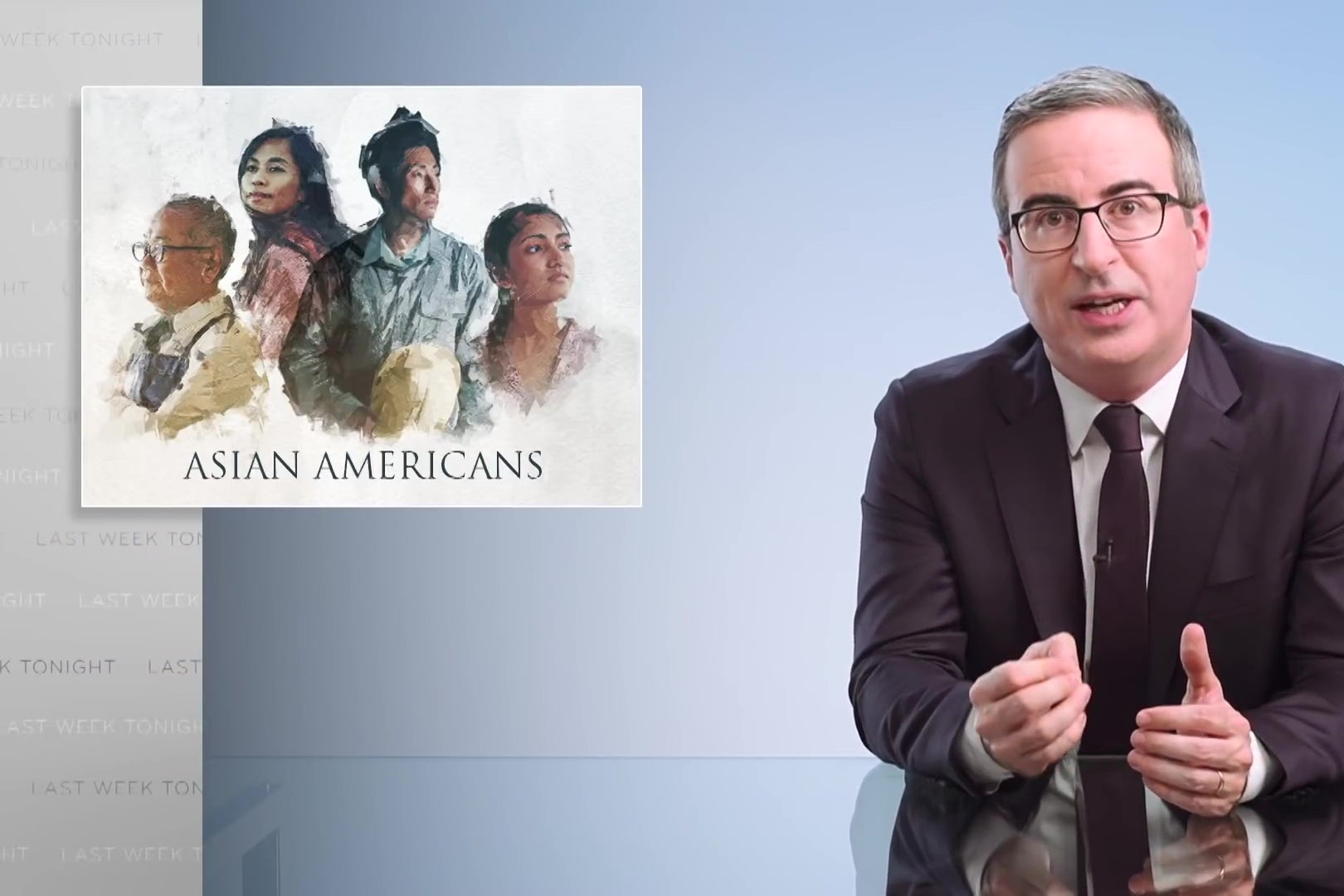 John Oliver sits at his glass anchor desk in front of a chyron reading "Asian Americans."
