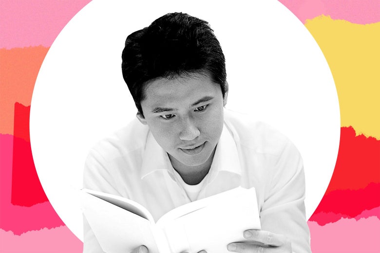 An Asian man reading a book.