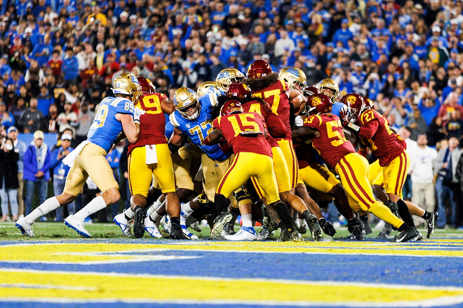 A large knot of USC Trojans and UCLA Bruins in a tense moment from a November 2022 game. 