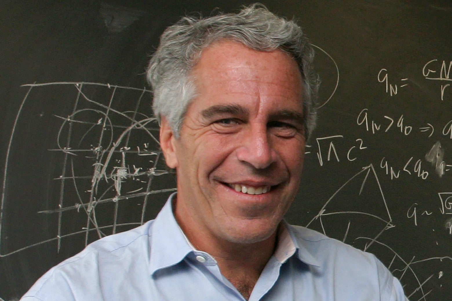 Jeffrey Epstein in front of a chalkboard with mathematical things written on it.