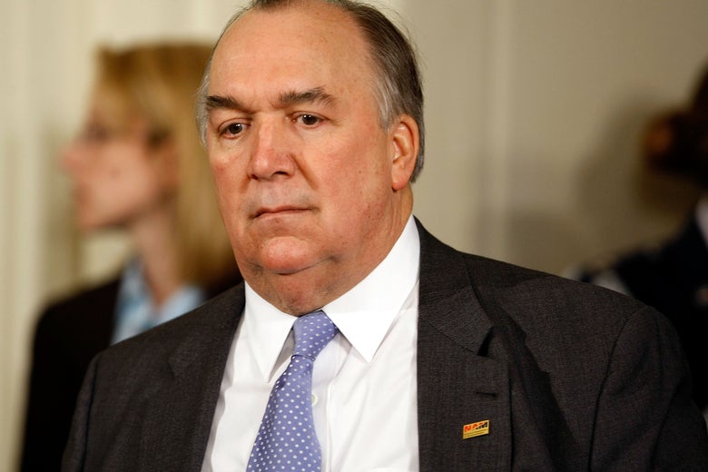 Engler, seen looking downward while wearing a suit.