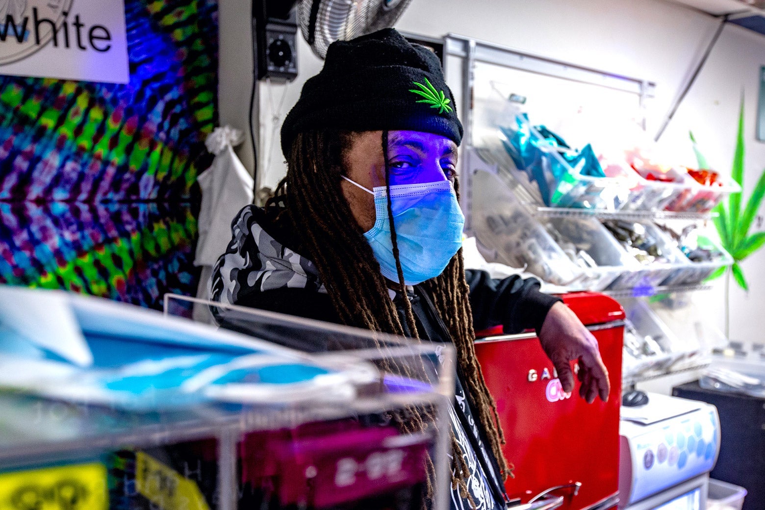 Ed Forchion, masked, in a colorful weed store in Trenton. 