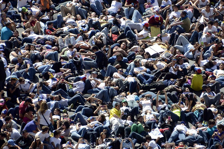 Thousands of anti-government students lie on the ground during a protest in front of the Venezuelan Judiciary building in Caracas.