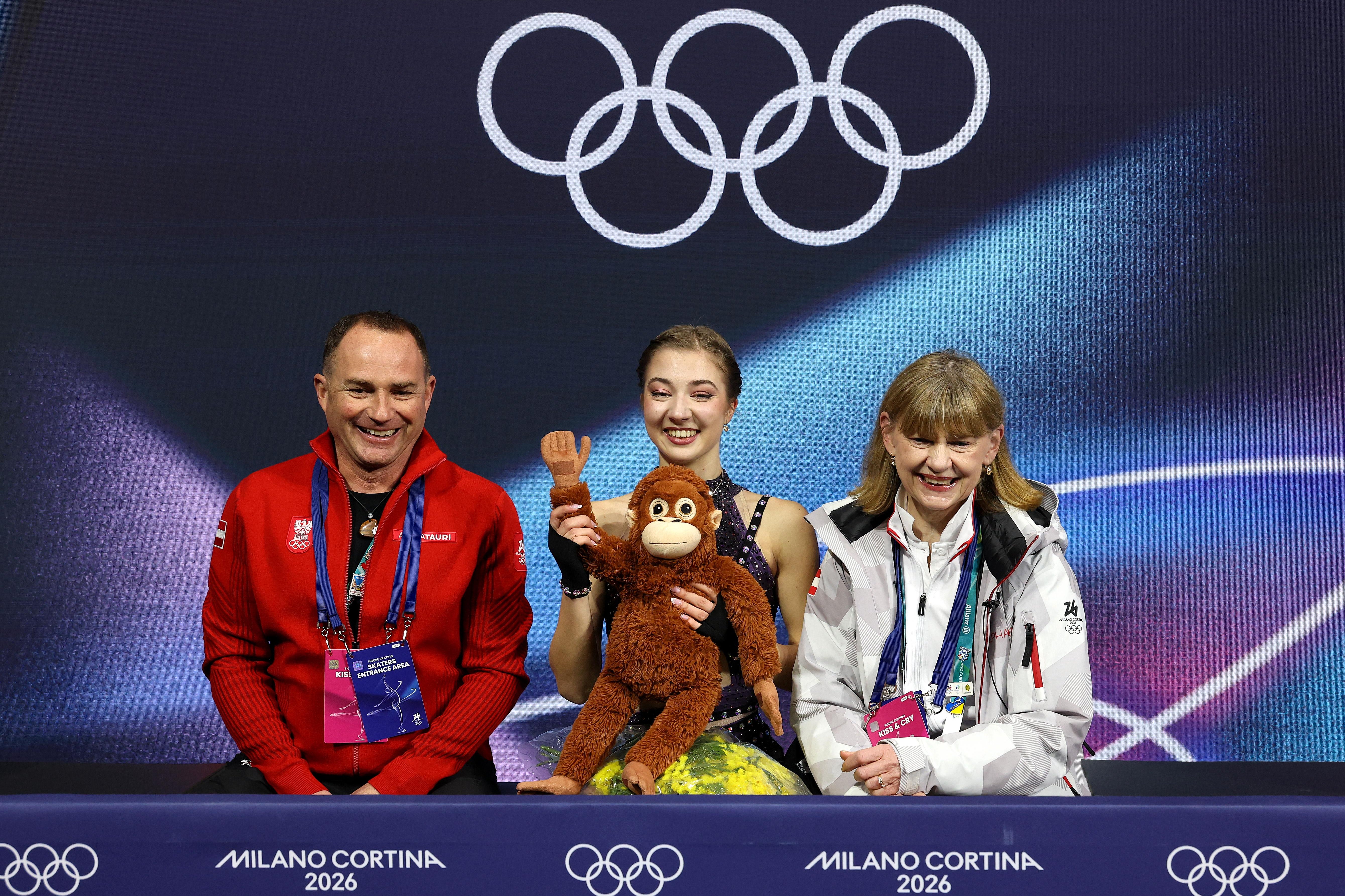 MILAN, ITALY - FEBRUARY 19: Olga Mikutina of Team Austria reacts with her team in the Kiss and Cry zone after competing in Women's Single Skating - Free Skating on day thirteen of the Milano Cortina 2026 Winter Olympic games at Milano Ice Skating Arena on February 19, 2026 in Milan, Italy. (Photo by Matthew Stockman/Getty Images)