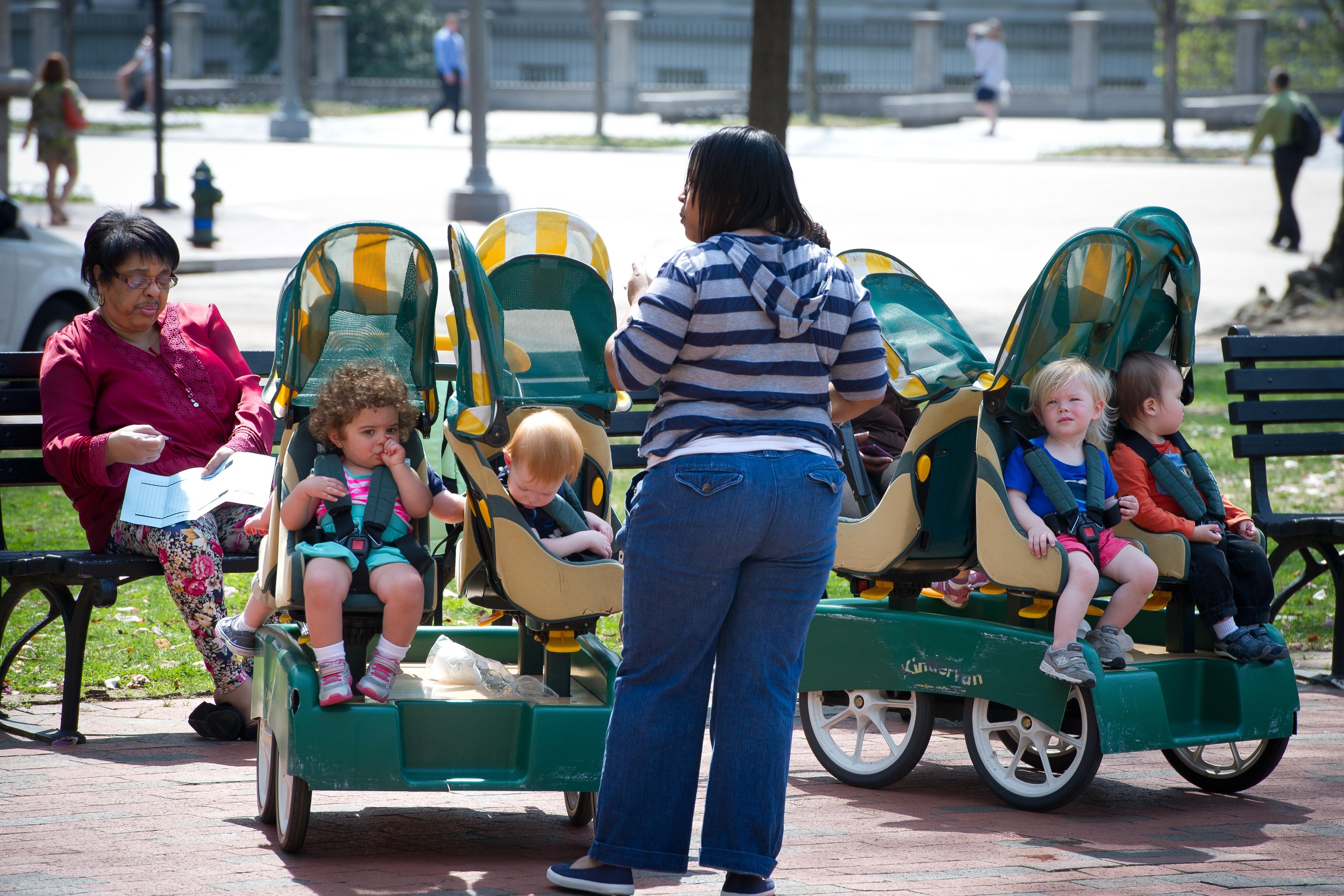 A daycare employee watches children in carts at a park in downtown Washington, DC on April 11, 2013. Delayed by unseasonably cold weather, Washington, D.C.'s cherry blossoms finally are in bloom. AFP PHOTO / MLADEN ANTONOV        (Photo credit should read MLADEN ANTONOV/AFP via Getty Images)