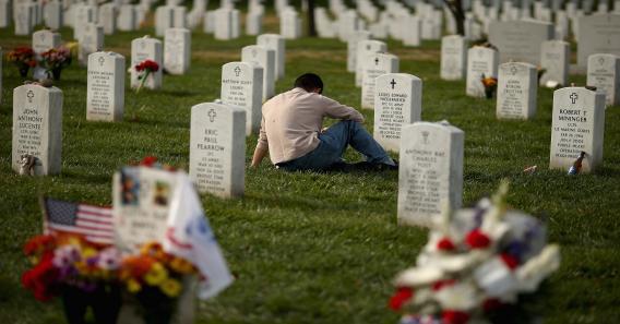 A man pauses between rows of headstones in Section 60, where most casualties of the wars in Afghanistan and Iraq are buried at Arlington National Cemetery.
