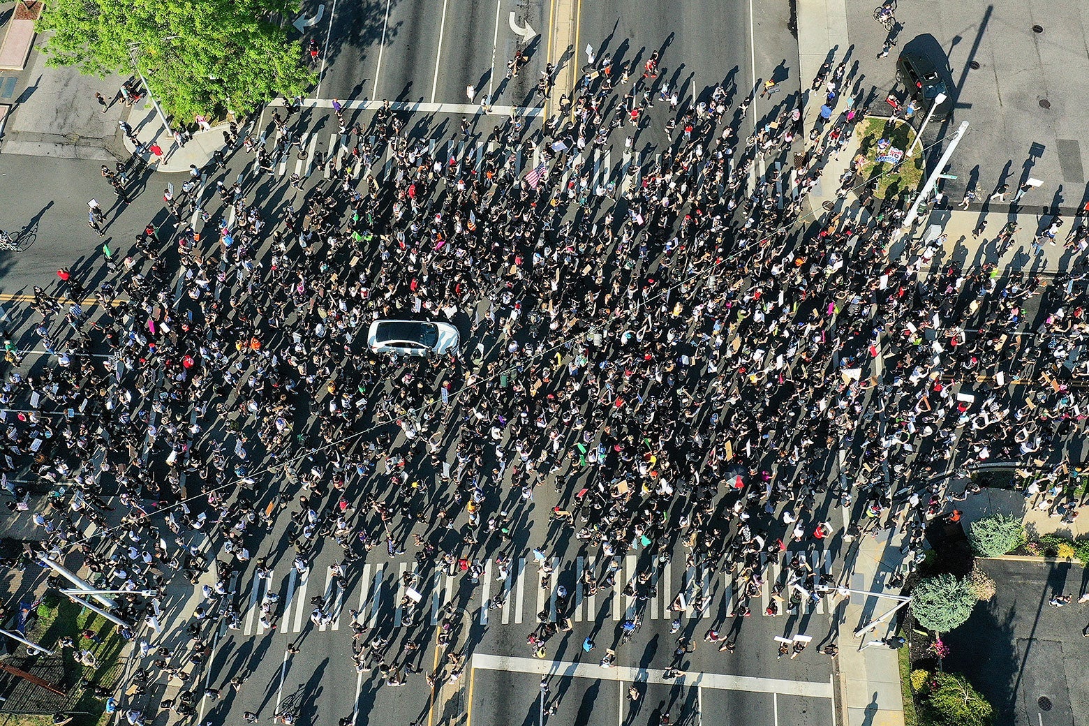 Aerial view of a large crowd of protesters marching through an intersection