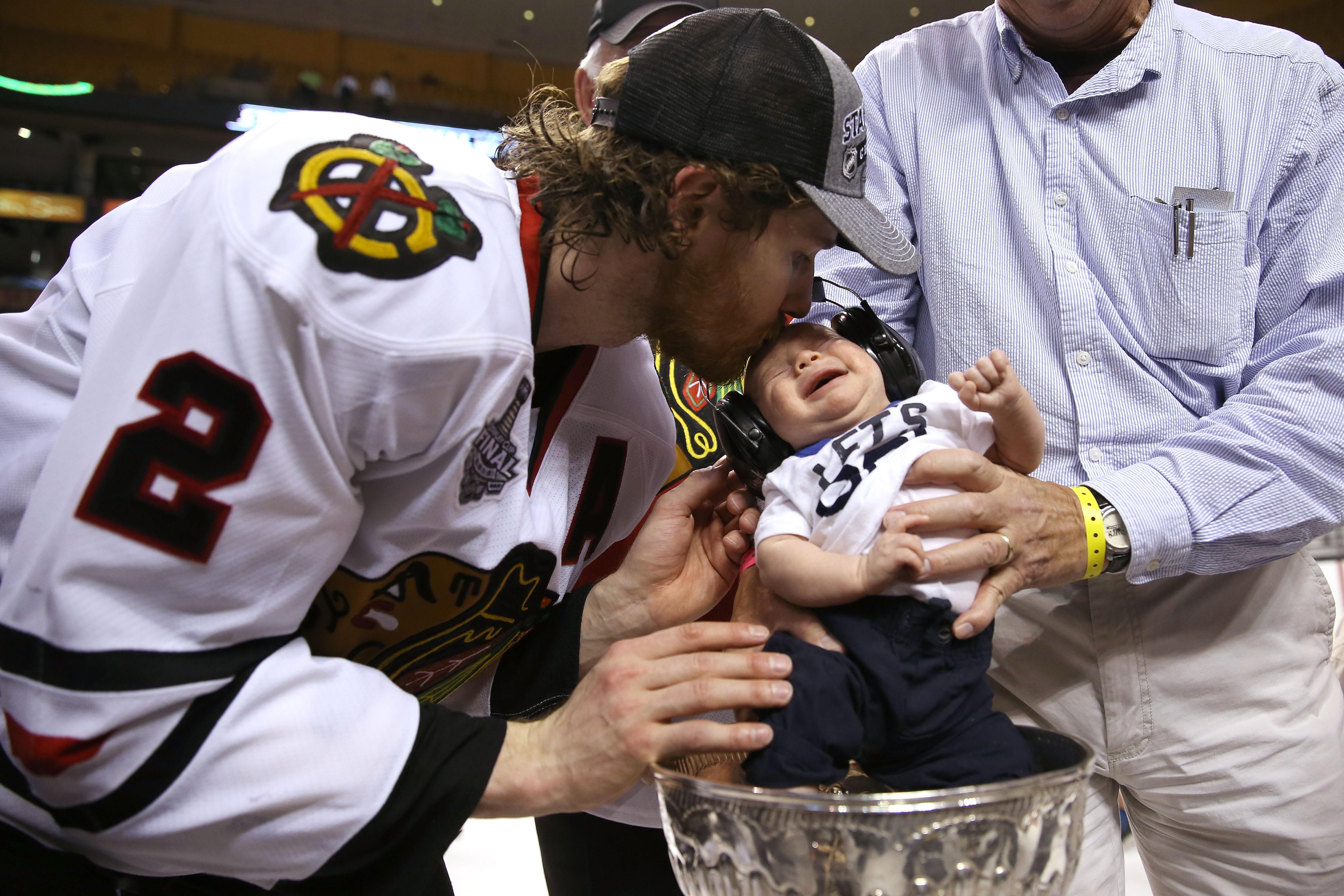 BOSTON, MA - JUNE 24:  Duncan Keith #2 of the Chicago Blackhawks celebrates a 2-1 victory over the Boston Bruins with his son following Game Six of the 2013 NHL Stanley Cup Final at TD Garden on June 24, 2013 in Boston, Massachusetts.  (Photo by Bruce Bennett/Getty Images)