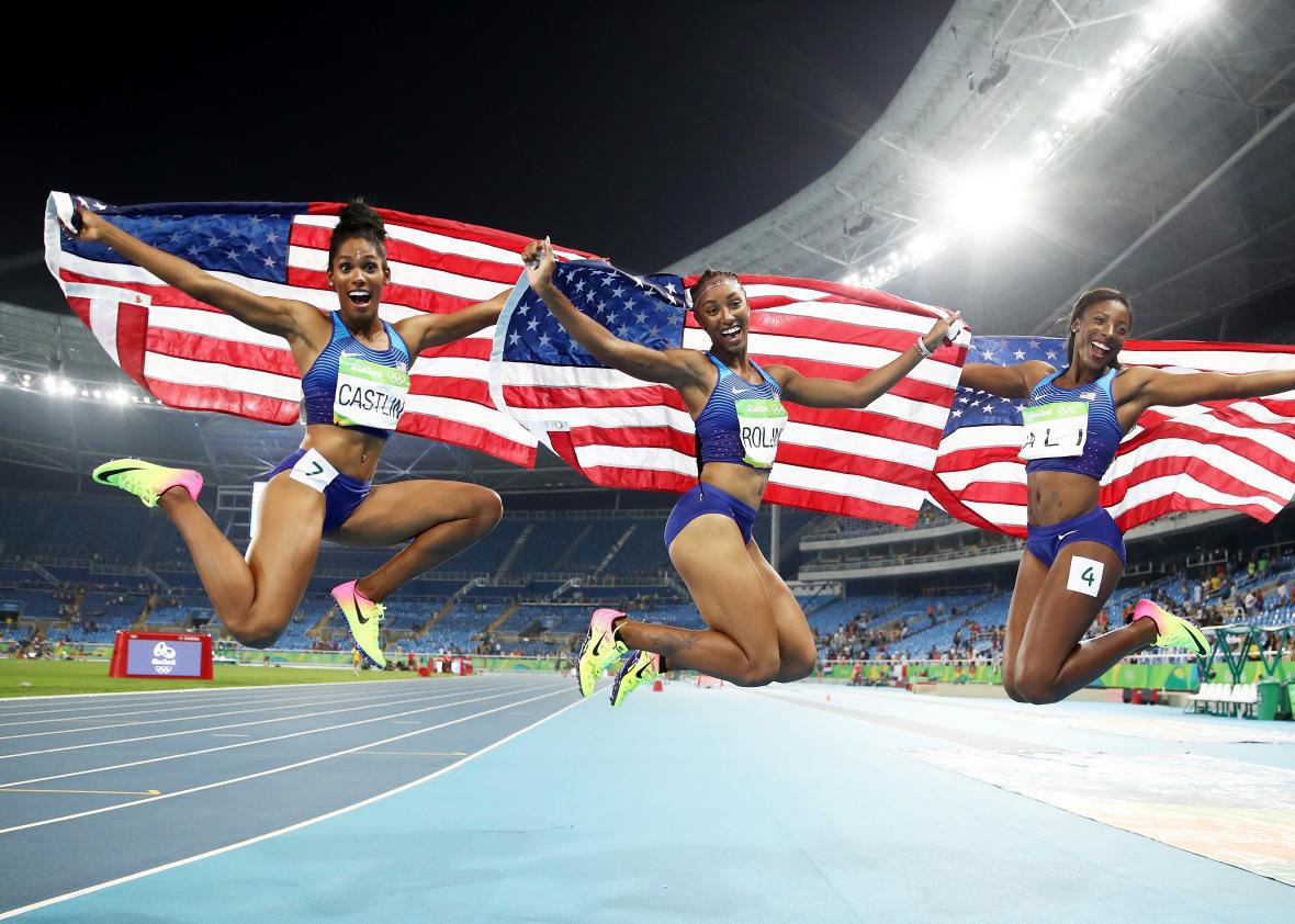 Bronze medalist Kristi Castlin, gold medalist Brianna Rollins, and silver medalist Nia Ali of the United States celebrate with American flags after the women's 100-meter hurdles final on Day 12 of the 2016 Olympic Games at the Olympic Stadium on Wednesday in Rio de Janeiro