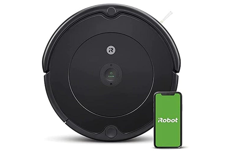 Roomba vacuum with a smartphone displaying the iRobot app beside it